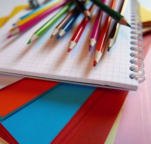 Close-up of colorful pencils on spiral notebook