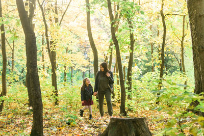 Rear view of two people standing in forest