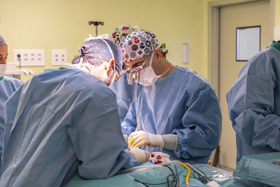 Surgeons performing surgery on patient in operating room