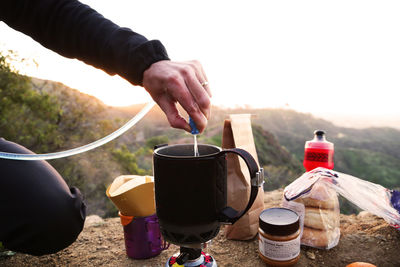Camper making coffee in mountains at sunrise