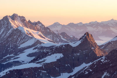 Scenic view of snowcapped mountains against sky during sunset