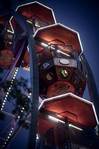 Low angle view of illuminated ferris wheel against building