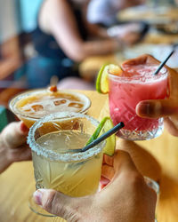 Close-up of hands holding cocktail drinks