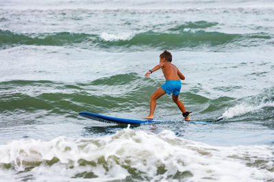 Full length of woman surfing in sea