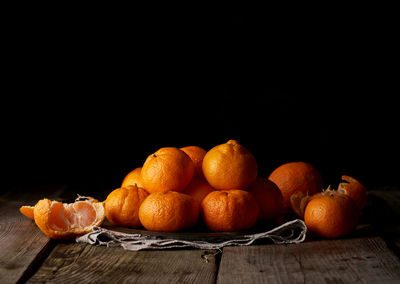 Close-up of fruits on table against black background