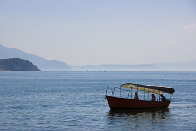 Boat moored in sea against clear sky