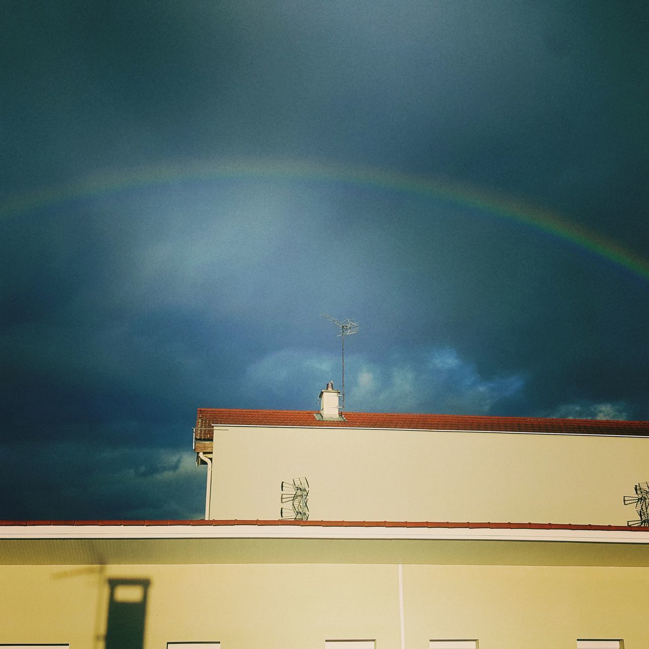 LOW ANGLE VIEW OF BUILDING AGAINST RAINBOW