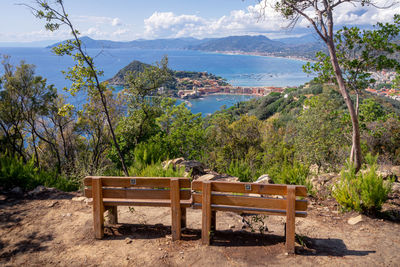 Chairs and table by sea against sky
