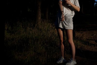 Low section of woman standing on field