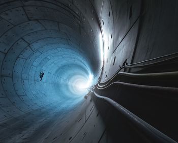 Silhouette man working in illuminated tunnel