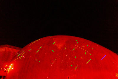 Low angle view of illuminated lamp against black background