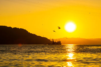 Scenic view of sea against orange sky