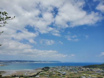 Aerial view of city by sea against sky