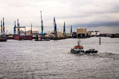 Ship moored at harbor against sky