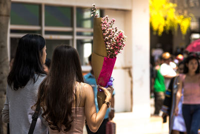 Rear view of women with flowers