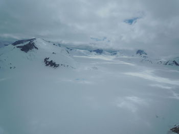 Snow covered mountain against cloudy sky