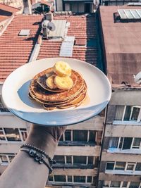 Cropped hand of person holding food in plate