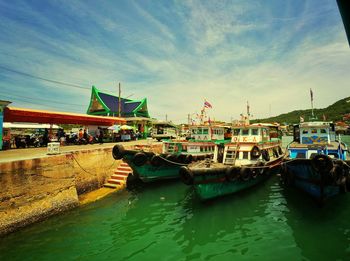 Boats moored on shore against sky