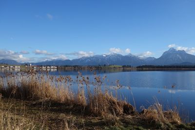 Scenic view of lake by mountains against sky