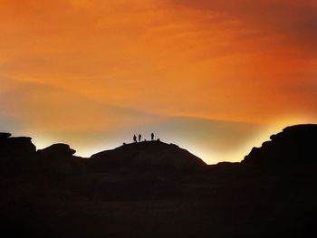 Scenic view of silhouette mountain against orange sky