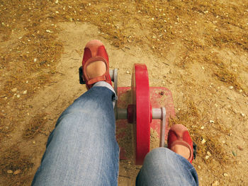 Low section of woman sitting on land