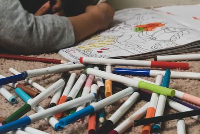 Cropped hands of girl coloring on book