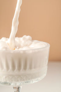 Milk pours into a beautiful crystal glass and splashes around.