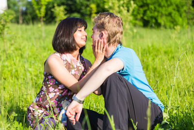 Young couple kissing on field