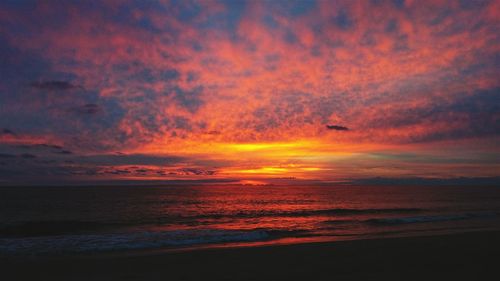 Scenic view of sea against dramatic sky during sunset