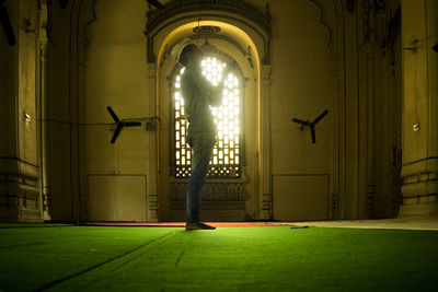 Side view full length of man praying in mosque