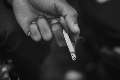 Close-up of hand holding cigarette