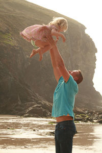 Full length of man playing with daughter on the beach