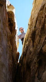 Low angle portrait of man standing on rock