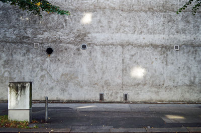 Empty road by wall in city