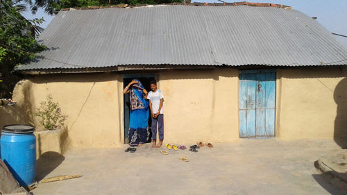 Portrait of people standing outside house