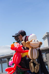 Man holding toy while standing against blue sky