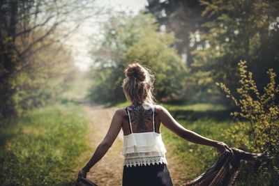 Rear view of woman standing against trees