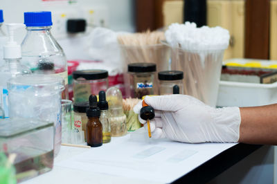 Cropped hand of scientist holding medical sample in container at laboratory