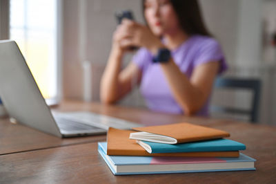 Midsection of man using mobile phone while sitting on table