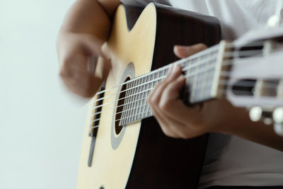 Midsection of man playing guitar