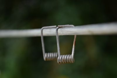 Close-up of rope hanging on metal fence