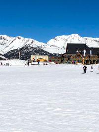 People walking on snowcapped mountain against sky