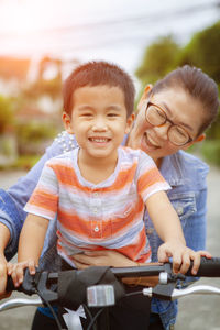 Grandson riding bicycle with grandmother in city