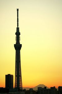 Low angle view of communications tower in city