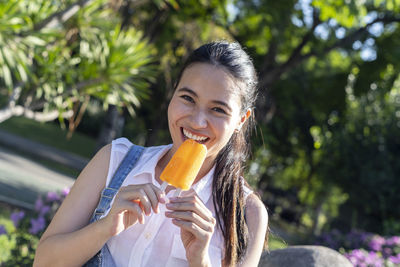 Portrait of smiling woman holding fruit