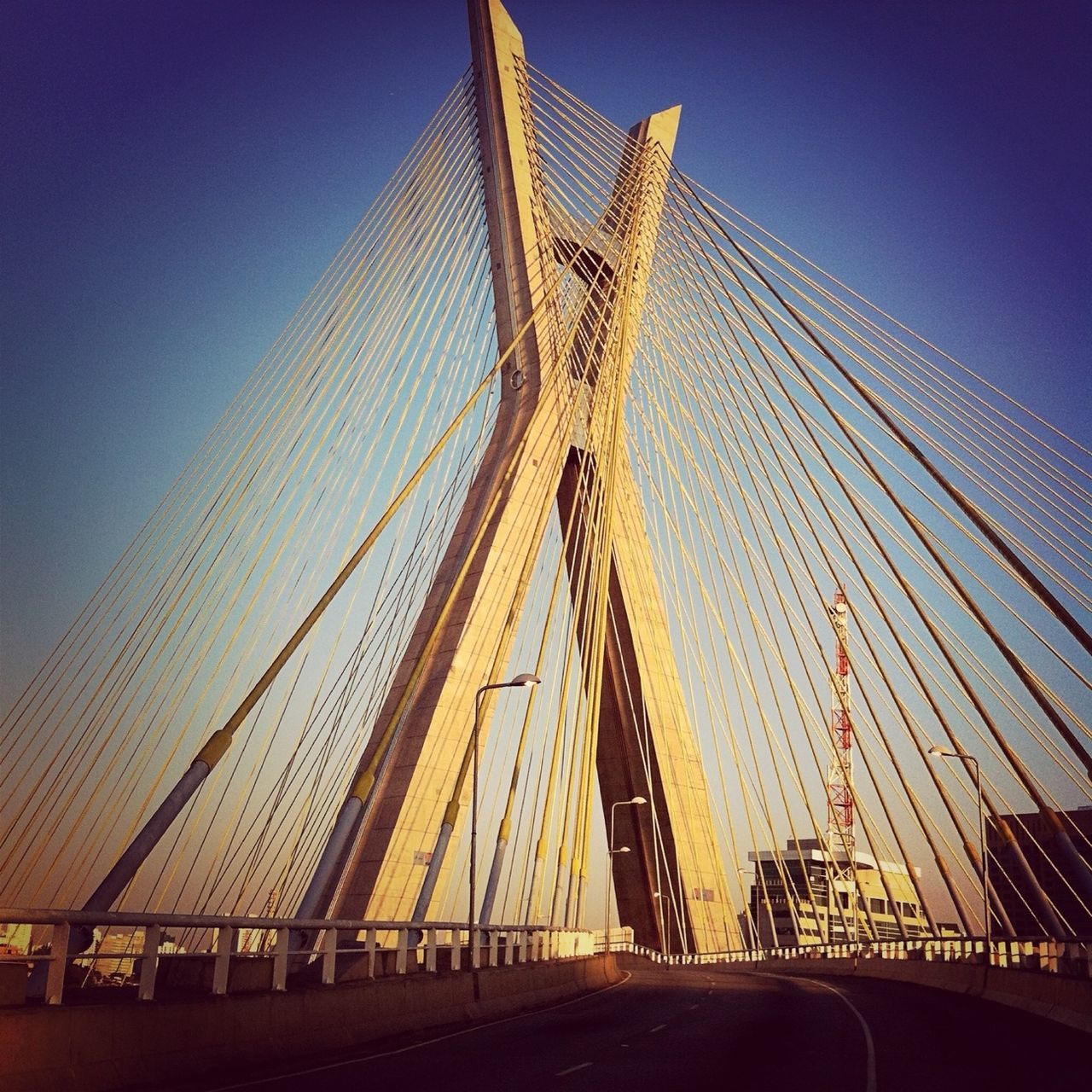 transportation, connection, bridge - man made structure, engineering, suspension bridge, the way forward, built structure, architecture, diminishing perspective, bridge, clear sky, cable-stayed bridge, road, sky, blue, vanishing point, long, travel, travel destinations, low angle view