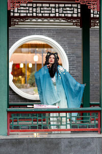 Portrait of young woman standing in city