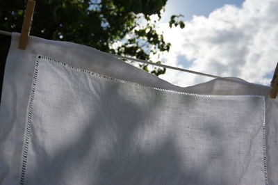 Close-up of clothes drying against sky