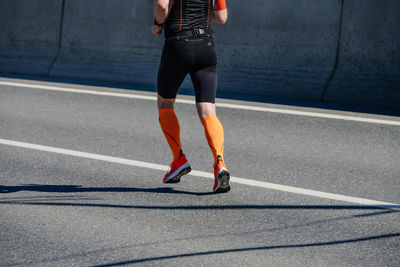 Low section of woman walking on road