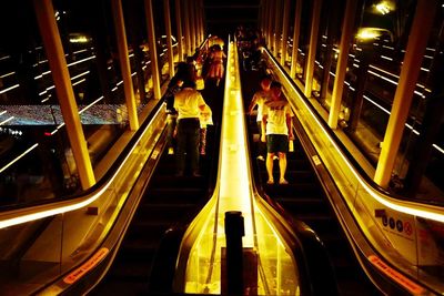 People on escalator at night